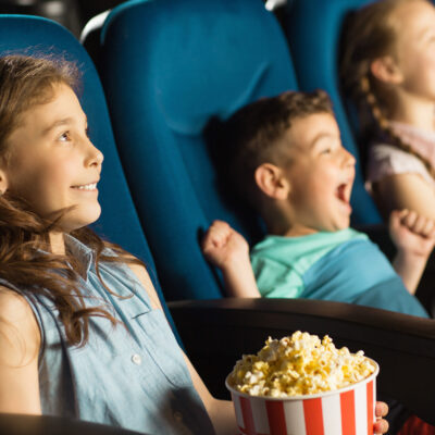 Cute little kids smiling joyfully watching a movie at the cinema entertainment childhood kids comedy cartoons family recreation leisure activity holidays positivity emotions concept